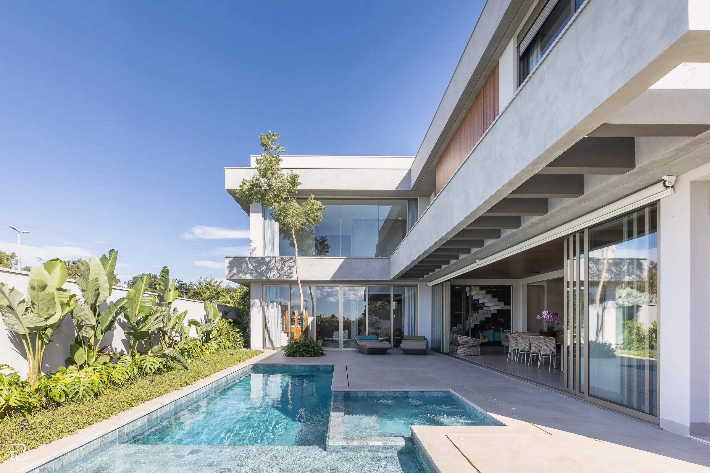 Casa contemporânea com piscina e jardim tropical